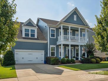 Charming two-story home featuring a covered front porch, attached garage, and manicured lawn at 500 Landau Rd, Waxhaw, NC 28173