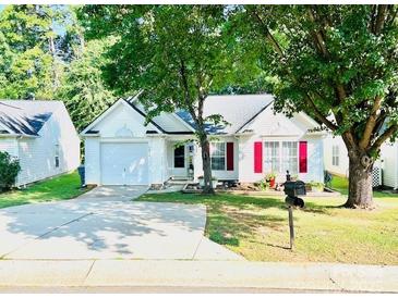 Charming single-story home with well-manicured lawn, mature trees, and a private driveway at 7215 Wingstone Ln, Charlotte, NC 28262