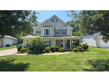 Charming two-story home with a well-manicured lawn and inviting front porch at 7731 Sedgebrook E Dr, Stanley, NC 28164