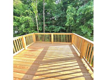 Wide shot of newly constructed wooden deck with wooden railing overlooking lush, green trees at 206 N Kayla Dr, Salisbury, NC 28146