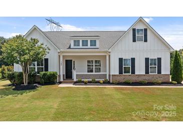 Charming single-Gathering home with a well-manicured lawn, front porch, and classic white siding at 152 Riverstone Dr, Davidson, NC 28036