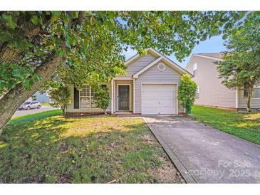 Charming one-story home featuring a single-car garage and well-maintained lawn, with a tree for shade at 1703 Southwind Dr, Charlotte, NC 28216
