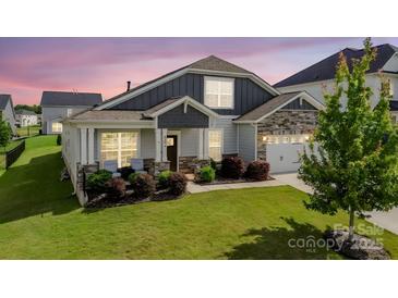 Charming single Gathering home with a well-manicured lawn and inviting front porch at 2296 Idol Rock Dr, Indian Land, SC 29707