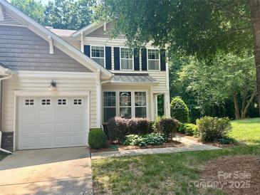 Charming home boasts a manicured lawn, attached garage, and inviting covered porch, complemented by lush landscaping at 2545 Chasewater Dr, Fort Mill, SC 29707