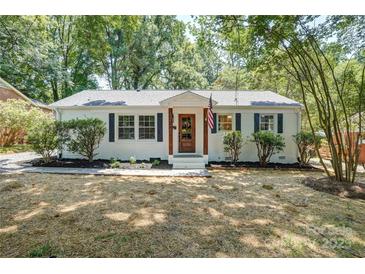 Charming single-story home featuring a white brick facade, dark shutters, and a well-manicured front yard at 4226 Raney Way, Charlotte, NC 28205