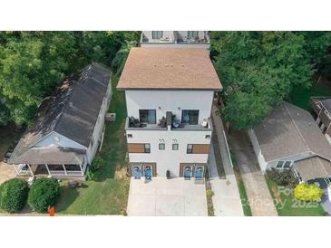 Aerial view of a modern home with white siding and a brown roof surrounded by lush trees in a suburban setting at 1113 Greenleaf Ave # B, Charlotte, NC 28202