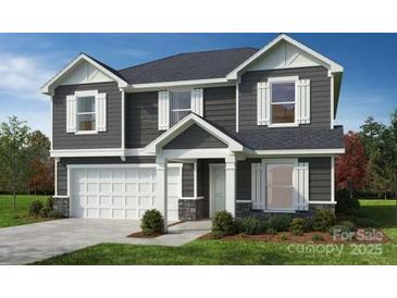 Charming two-story home with gray siding, white trim, a two-car garage, and a well-manicured front lawn at 12591 Forager Pl # 92, Midland, NC 28107