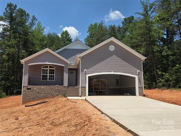New construction home featuring a gray exterior, covered porch, and attached garage at 153 Brook Creek Dr, Troutman, NC 28166