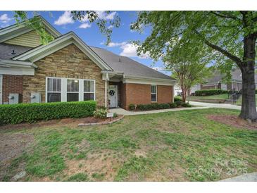 Charming home featuring a stone facade, brick accents, well-maintained lawn, and manicured landscaping at 2959 Bellasera Way, Matthews, NC 28105