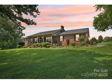 Sprawling brick ranch home with a lush, landscaped front yard and a covered front porch at 3381 Elaine Ave, Lincolnton, NC 28092