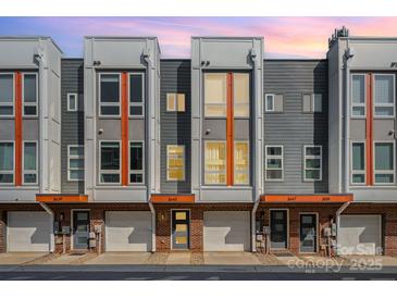 Modern townhome exterior featuring brick accents, multiple windows, and individual garages in a contemporary design at 3643 Vallette Ct, Charlotte, NC 28203