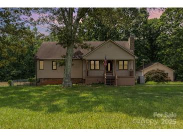 Charming single-Gathering home with a welcoming front porch, mature trees, and a detached garage at 544 Hicks Creek Rd, Troutman, NC 28166