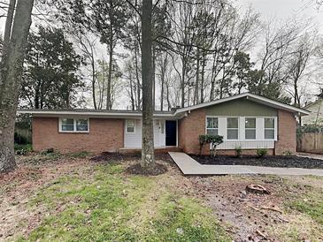 Charming single-story brick home with a well-manicured lawn and mature trees, offering great curb appeal at 6513 Old Post Rd, Charlotte, NC 28212