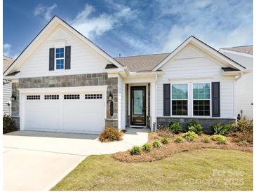 Charming single-story home with a two-car garage, stone accents, and a well-manicured front yard at 7337 Overjoyed Xing, Charlotte, NC 28215