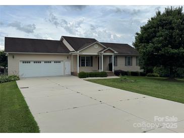 Charming ranch-style home with a well-manicured front yard and a two-car attached garage and long driveway at 1519 Midland Dr, Hudson, NC 28658