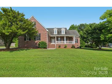 Charming brick home featuring a large front yard and inviting covered porch at 2411 Stoney Run Dr # 13, Oakboro, NC 28129