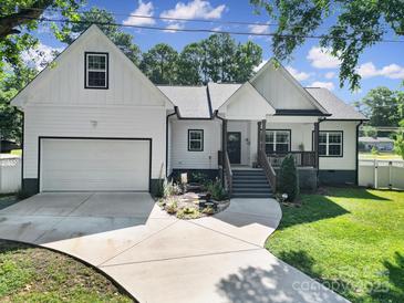 Charming white two-story home features a well-manicured lawn and an attached garage with a concrete driveway at 333 Anne Ave, Waxhaw, NC 28173