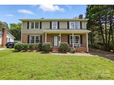 Charming two-story home with brick facade, well-manicured lawn, and inviting front porch at 6319 Welford Rd, Charlotte, NC 28211