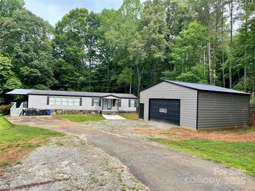 Charming home with a large garage, surrounded by lush greenery and a well-maintained driveway at 6490 Alta Ctr, Denver, NC 28037