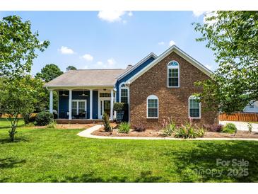 Beautiful brick and siding home with manicured lawn and welcoming front porch at 13733 Castleford Dr, Mint Hill, NC 28227