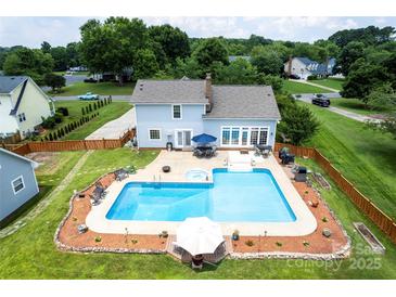 Aerial view of home with large pool, hot tub, patio area, and well-manicured lawn at 13733 Castleford Dr, Mint Hill, NC 28227