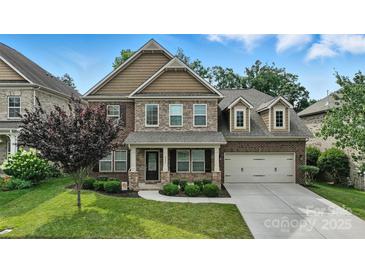 Beautiful two-story home featuring a well-manicured lawn, brick and stone accents, and an attached two-car garage at 2377 Maple Grove Nw Ln, Concord, NC 28027