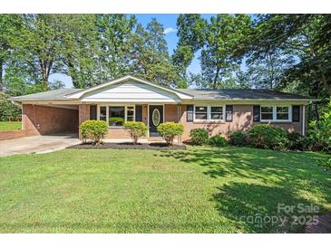 Charming brick home with a well-manicured lawn and mature trees creating a welcoming curb appeal at 4322 Greenhaven Ln, Gastonia, NC 28056