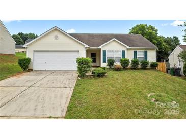 Charming single-story home featuring a two-car garage, well-manicured lawn, and classic vinyl siding at 7616 Shiny Meadow Ln, Charlotte, NC 28215