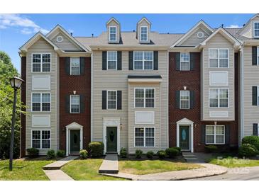 Charming townhome featuring a well-maintained lawn, brick accents, and a welcoming entryway at 10094 Treeside Ln, Matthews, NC 28105