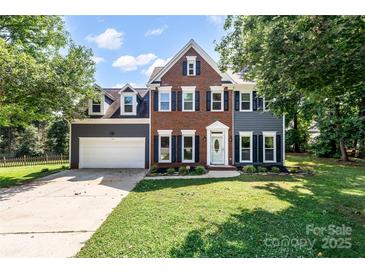 Charming two-story home with a brick and gray siding exterior, featuring a well-manicured lawn and attached garage at 1581 Bluff Ct, Rock Hill, SC 29732