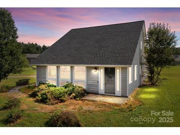 Charming single-story home with large windows, well-kept lawn, and mature landscaping at 2268 Bay Ct, Newton, NC 28658