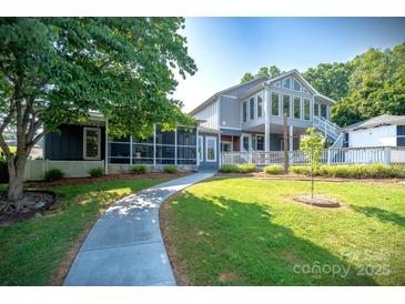 Beautiful two-story home featuring a spacious yard, screened porch, and a welcoming entrance at 47209 Paradise Ln, Norwood, NC 28128