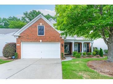 Charming brick home featuring an attached two-car garage, manicured lawn, and mature shade tree at 8637 Annabel Lee Ln, Charlotte, NC 28277