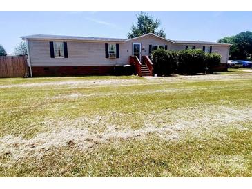 Charming single-story home features a spacious front yard and inviting front porch at 1064 Calico Farm Ct, Cleveland, NC 27013