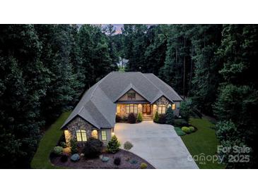 Stunning stone home with lush landscaping and a circular driveway creates an inviting curb appeal at 146 Bullfinch Rd, Mooresville, NC 28117