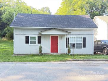 Charming bungalow with a bright red door, complemented by black shutters and manicured landscaping at 409 W Norment Ave, Gastonia, NC 28052