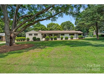 Charming single-story home with fresh exterior paint, green lawn, and manicured shrubbery at 4209 Windwood Cir, Charlotte, NC 28226