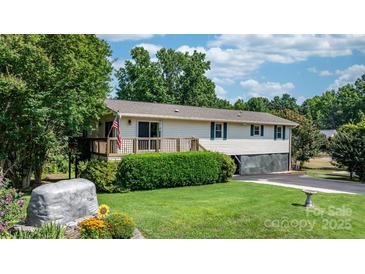 Charming home featuring a well-maintained lawn, a wooden deck, and a classic American flag at 4278 Harbor Ln, Sherrills Ford, NC 28673