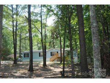 Charming single-story home features a classic facade with inviting front porch and lush, wooded surroundings at 561 Woodglenn Rd, Catawba, SC 29704