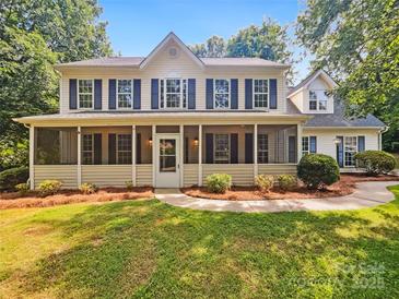 Charming two-story home with a screened-in front porch and well-maintained landscaping at 8701 Holly Creek Ct, Charlotte, NC 28216