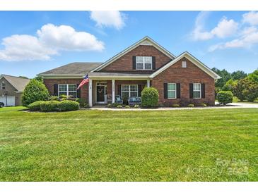 Charming brick home with a manicured lawn and inviting front porch at 1006 Spring Rose Ln, Matthews, NC 28104