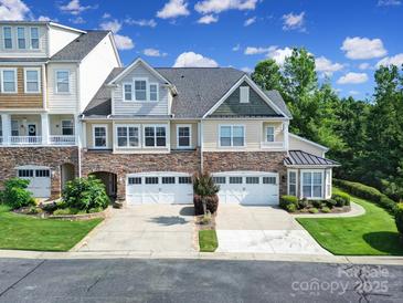 Beautiful townhome with stone accents, two-car garage, and manicured lawn, perfect for comfortable living at 329 Wave Crest Dr, Tega Cay, SC 29708