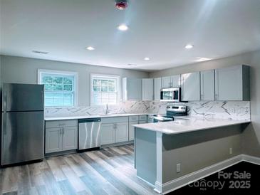 Bright, updated kitchen featuring stainless steel appliances and stone countertops with bar seating at 509 8Th Avenue Ext, Cramerton, NC 28032