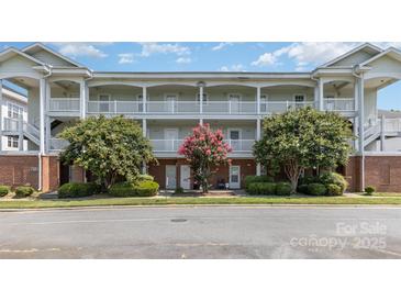 Well-maintained condo building featuring two stories with white railings and mature landscaping at 9271 Meadow Vista Rd, Charlotte, NC 28213