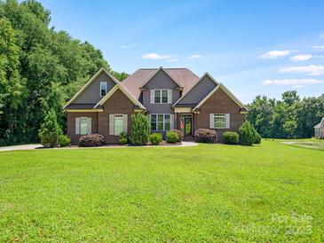 Charming brick home with a well-manicured lawn and landscaping provides excellent curb appeal at 1011 Duntov Dr, Monroe, NC 28110