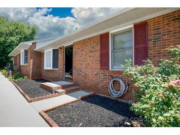 Charming brick home featuring a well-maintained front yard with red shutters and tidy landscaping at 1140 Mckinnon Dr, Rock Hill, SC 29732