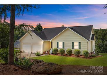 Charming single Gathering home featuring a well-manicured lawn and a two car garage at dusk at 2906 Plantation Way, Albemarle, NC 28001