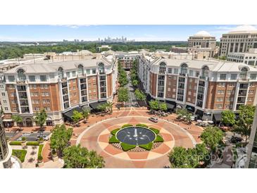 Aerial view of building with fountain in a circular driveway with trees and Charlotte, NC skyline in background at 4625 Piedmont Row Dr, Charlotte, NC 28210