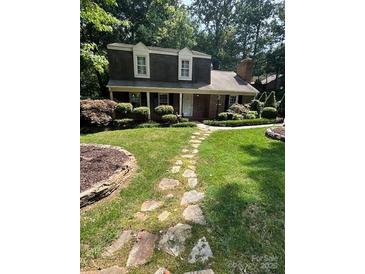 Charming two-story home with landscaped yard and a stone walkway leading to the front door at 101 Treeline Dr, Belmont, NC 28012