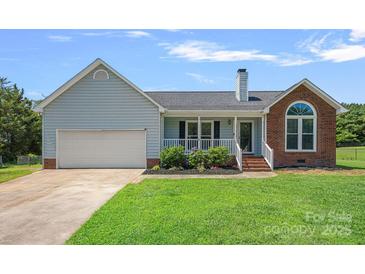 Charming single-Gathering home featuring a two-car garage, brick accents, and a well-maintained front lawn at 142 Family Ln, Mount Holly, NC 28120